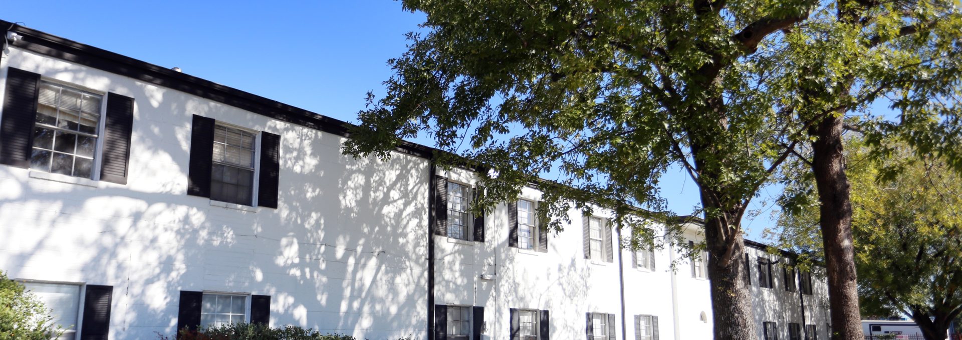 the exterior of an apartment building with trees and bushes at The Vista Villa Apartments